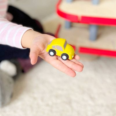 Kleines Spielzeugauto auf Kinderhand
