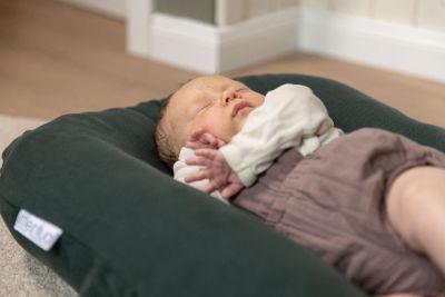 Baby schläft im Babynest unter Aufsicht