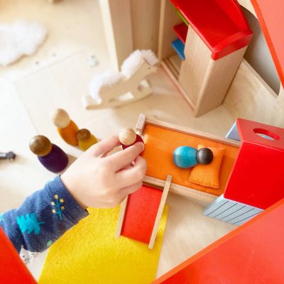 Junges Kind spielt mit Holz Puppenhaus