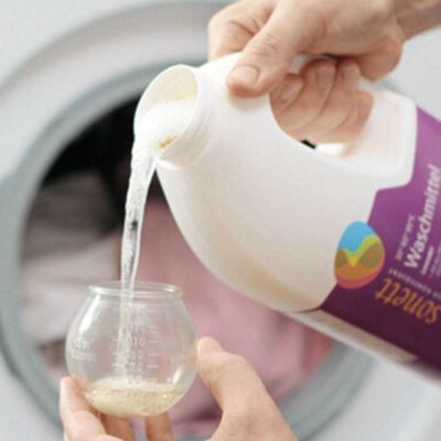 Flüssig Waschmittel dosiert vor Waschmaschine