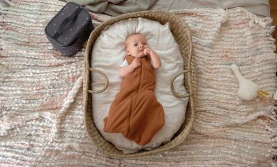 Baby trägt braunen Bio Sommerschlafsack
