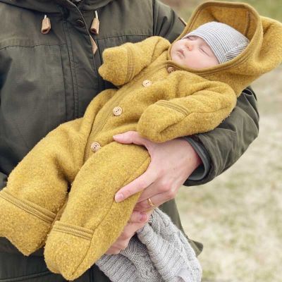 Baby im gelben Wolloverall natürliche Babykleidung