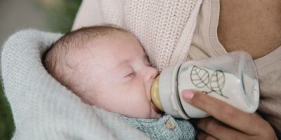 Baby gefüttert mit Glas Babyflasche